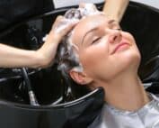Une femme se fait masser le crâne par sa coiffeuse