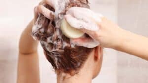 Une femme se faisant un shampoing après une teinture végétale pour cheveux