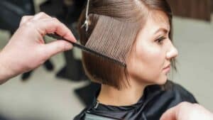 Une femme qui se fait coiffer dans un salon de coiffure