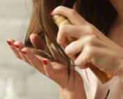 Une femme s'applique de l'huile sur les cheveux