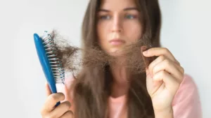 perte-de-cheveux-stress femmme-observant-sa-perte-de-cheveux-stress