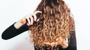 penetration-de-produits-cheveux Une femme qui se met du produit pour les cheveux