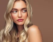 Image d'une femme qui pose sur fond marron pour montrer son babylight blond