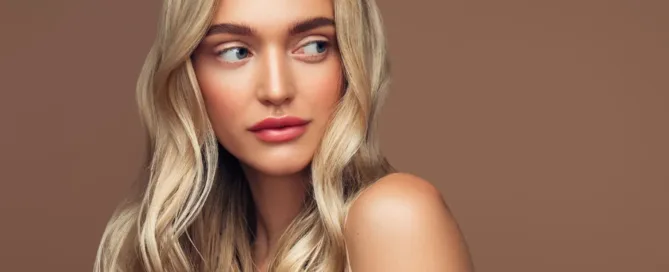 Image d'une femme qui pose sur fond marron pour montrer son babylight blond