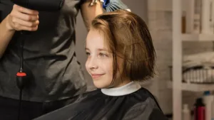 Un jeune garçon qui fait un carré dégradé chez le coiffeur