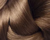 Gros plan sur la texture de cheveux bruns sains et brillants.