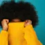 Femme avec une coiffure afro volumineuse, exemple d'une routine capillaire pour cheveux crépus réussie.