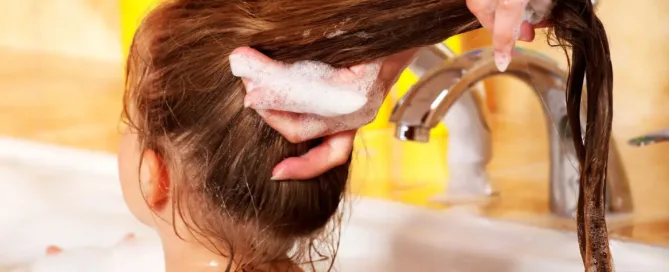 Une femme fait un shampoing à une petite fille