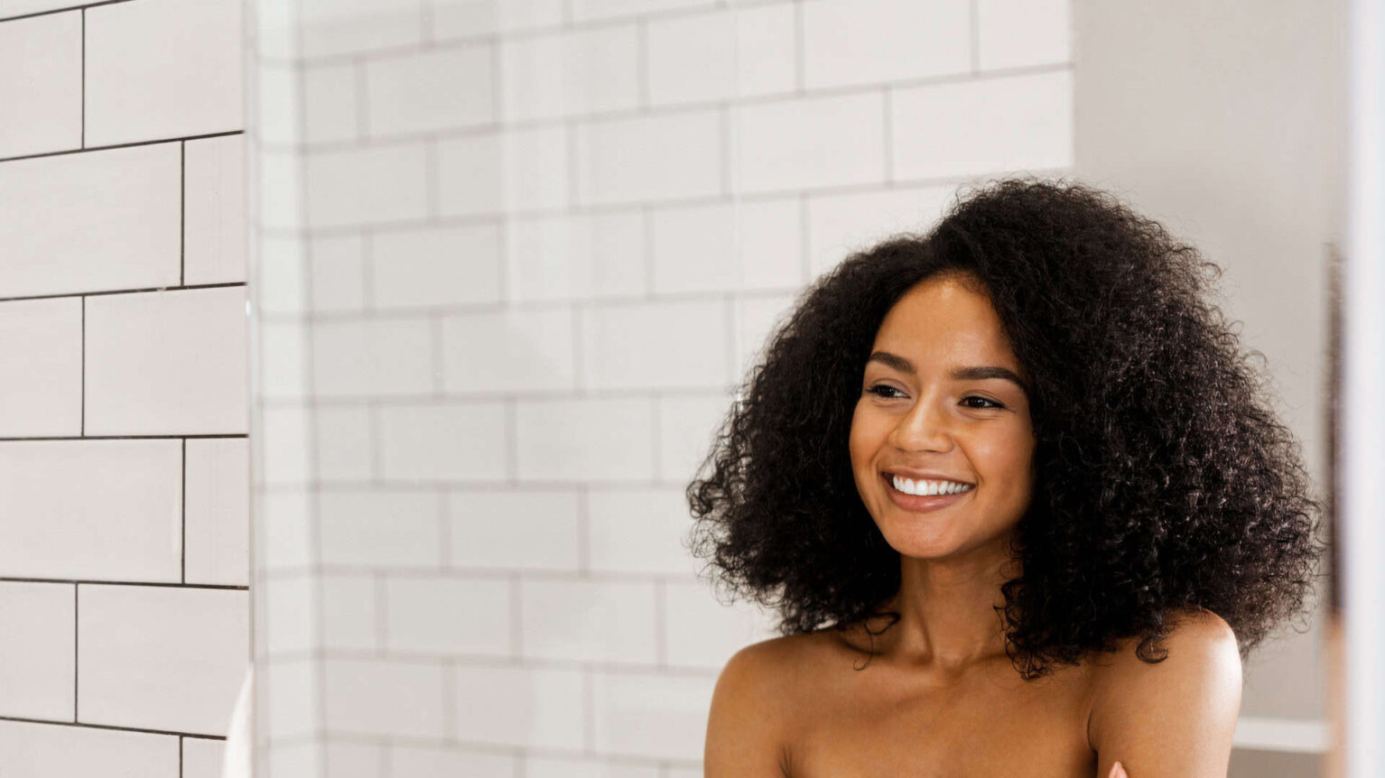 Une femme aux cheveux bouclés souriante