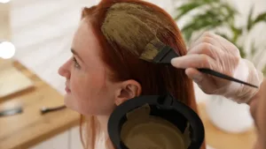 Quelqu'un applique une coloration végétale maison à une rousse