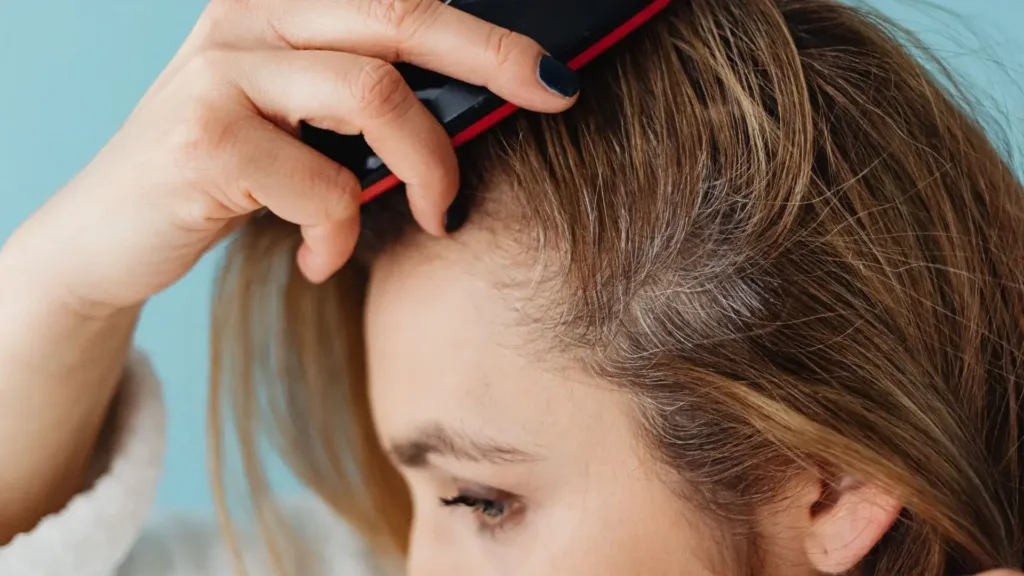 Une femme avec le cuir chevelu sensible se brosse