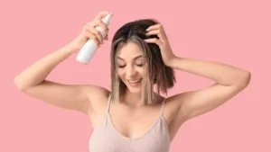 Une femme applique un spray protecteur sur ses cheveux