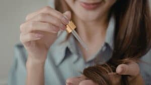 Une femme applique un soin detox cheveux