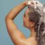 Une femme se lave les cheveux avec du shampoing après-soleil bio