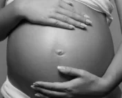 image en noir et blanc qui montre le ventre d'une femme enceinte