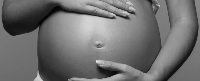 image en noir et blanc qui montre le ventre d'une femme enceinte