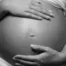 image en noir et blanc qui montre le ventre d'une femme enceinte