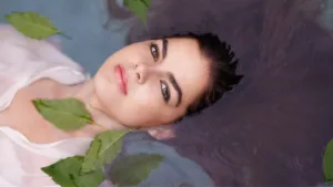 femme qui a la tête dans l'eau avec des feuilles qui flottent autour d'elle 