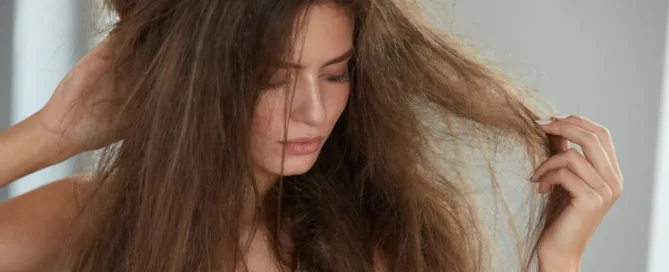 femme qui regarde ses cheveux en mauvais état