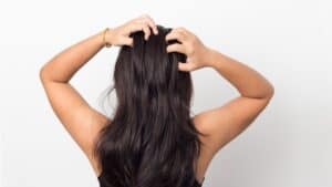 Une femme se gratte les cheveux