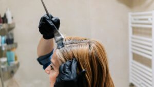 Une femme s'applique une coloration à la maison